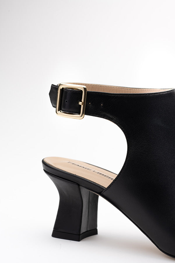 Close up shot of the buckle of a black cute buckle shoes on a white background