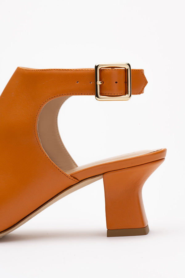 Closeup of a  leather buckle shoe buckle on a white background shot from the side 