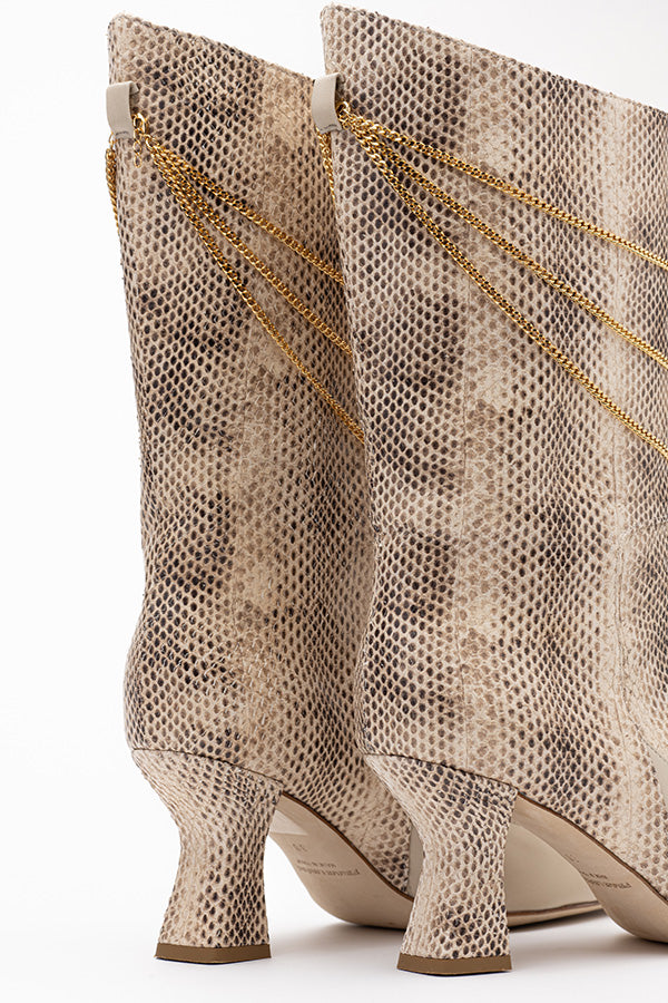 Zoom in on the 70 mm heel of the Naomi Ivory Python Print Boot shot from behind on white background
