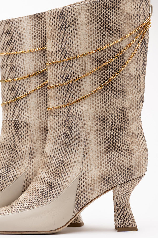 Zoom in on the 70 mm heel of the calf high boots for women Naomi Ivory Python Print Boot shot from the side on white background