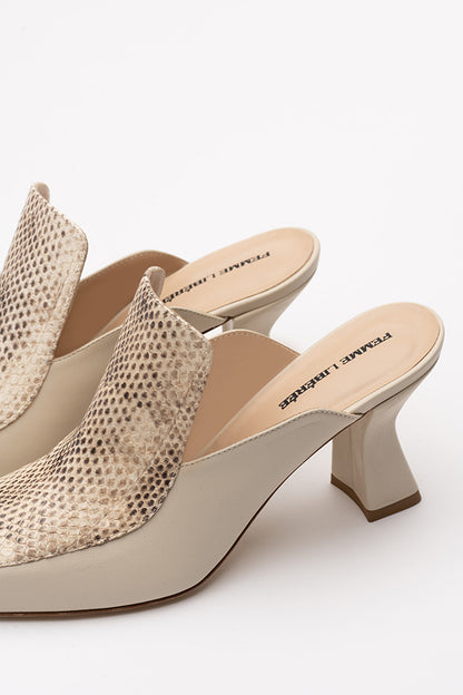 Two ivory mule shoes on a white background shot from the side and above