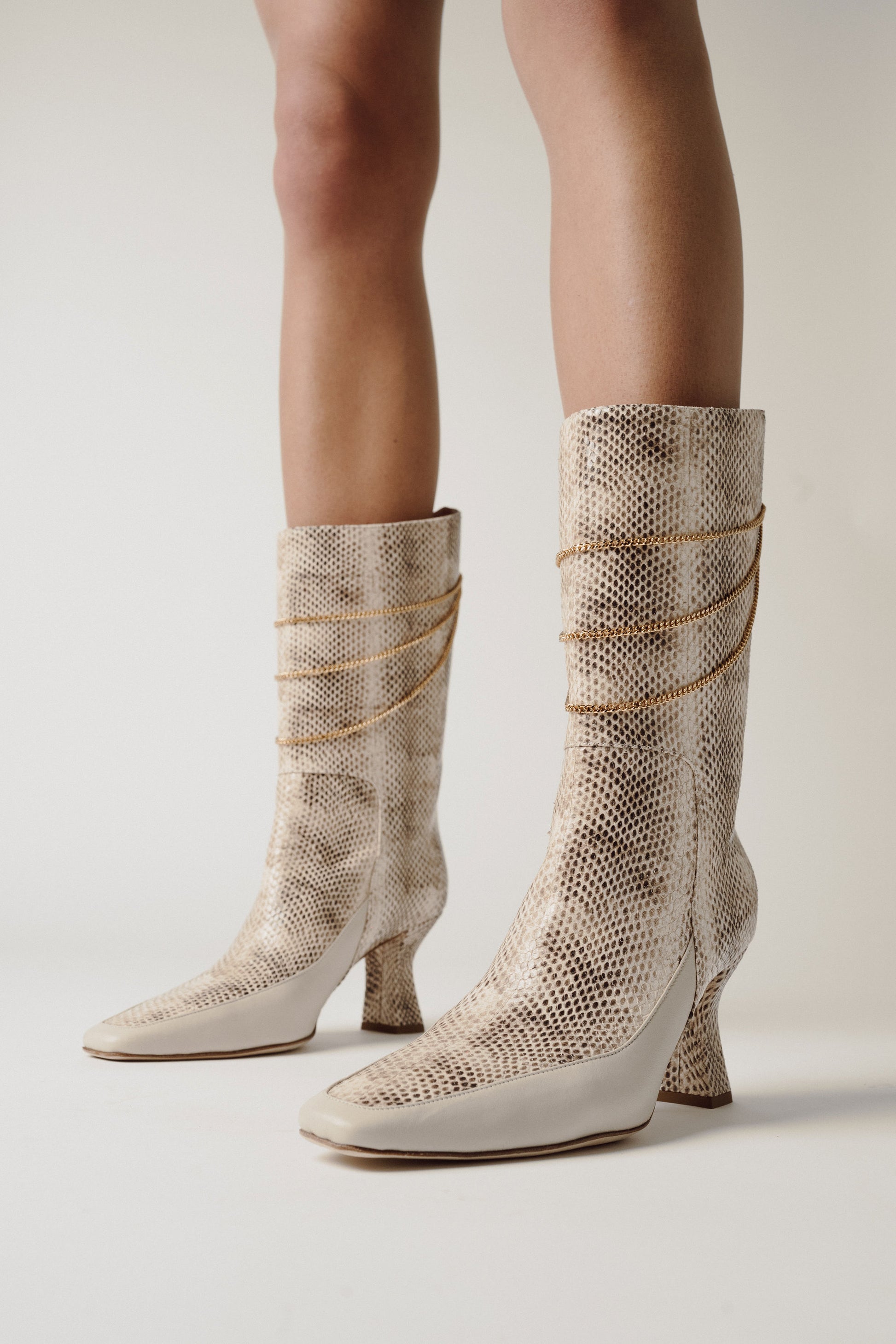 woman legs with python leather boots Naomi Ivory Python Print Boot in grey room
